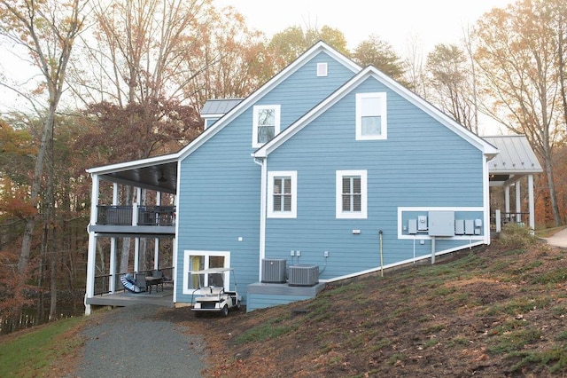 view of side of property with a balcony and central AC unit