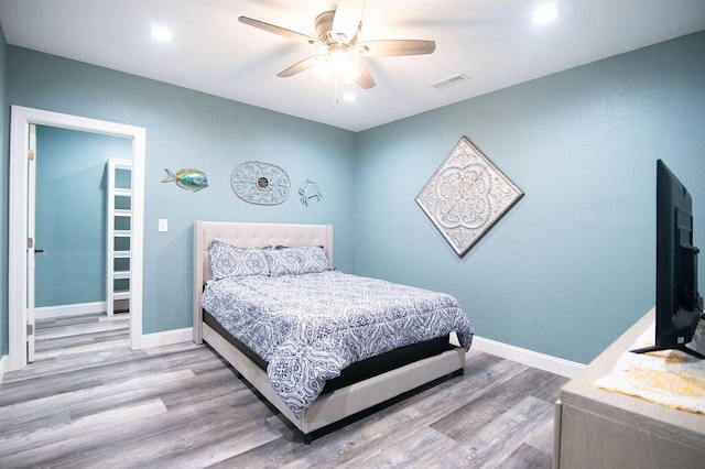 bedroom with light hardwood / wood-style flooring and ceiling fan