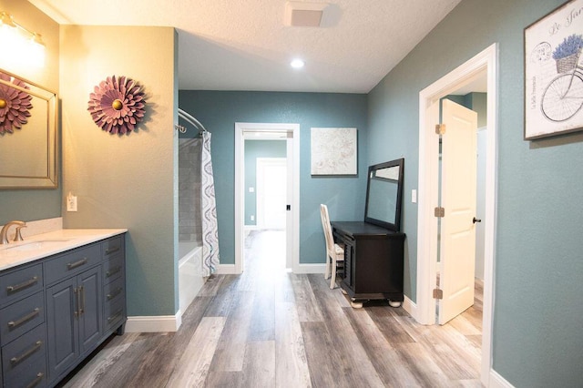 bathroom with shower / bath combo, wood-type flooring, a textured ceiling, and vanity