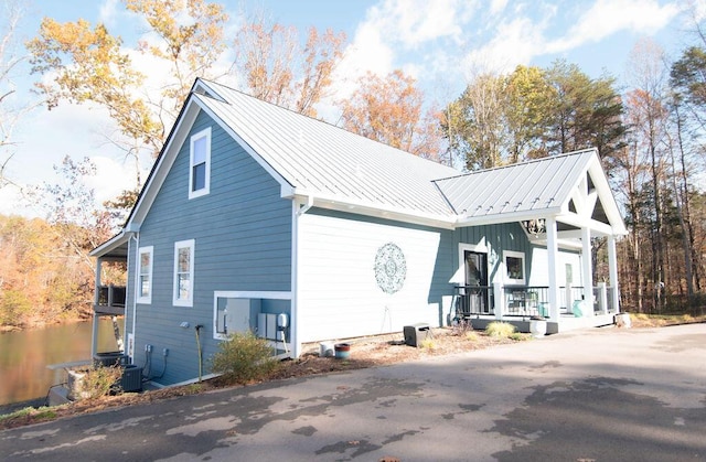 view of side of home with covered porch and central air condition unit