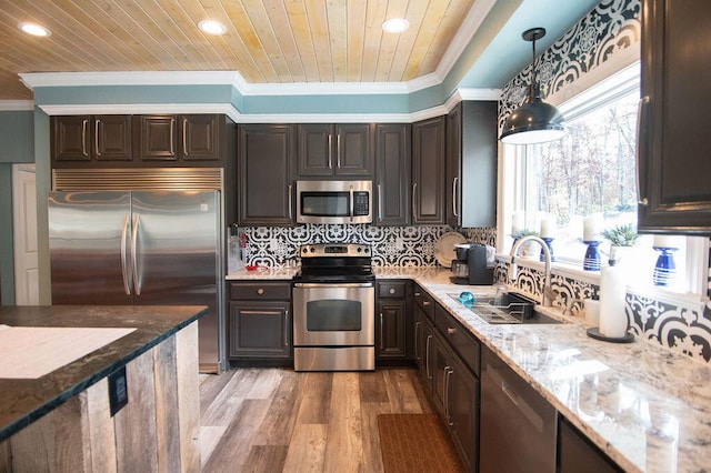 kitchen featuring dark brown cabinetry, sink, stainless steel appliances, pendant lighting, and light wood-type flooring