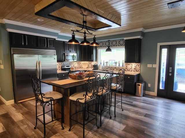 kitchen with appliances with stainless steel finishes, ornamental molding, wood ceiling, pendant lighting, and dark hardwood / wood-style floors