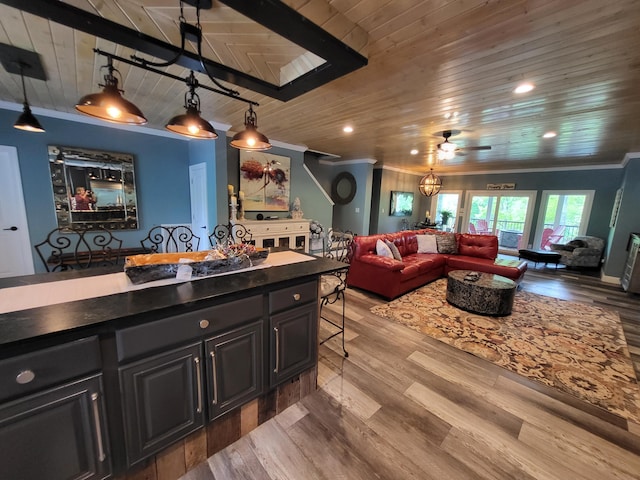 kitchen with pendant lighting, ceiling fan, a breakfast bar area, and wood ceiling