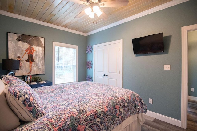 bedroom with ceiling fan, wooden ceiling, wood-type flooring, a closet, and ornamental molding