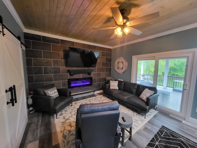 living room with hardwood / wood-style floors, wooden ceiling, crown molding, ceiling fan, and a barn door