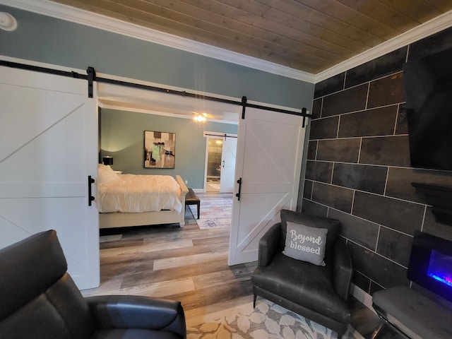 bedroom featuring wooden ceiling, a barn door, ornamental molding, tile walls, and light wood-type flooring