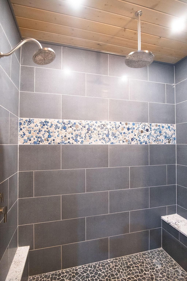 bathroom featuring a tile shower and wood ceiling