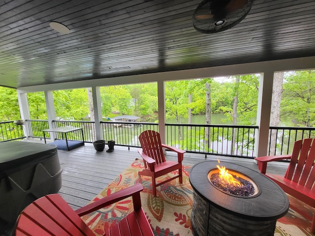 wooden terrace with a water view and an outdoor fire pit