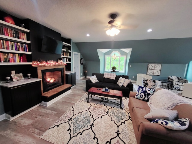 living room with ceiling fan, built in features, light hardwood / wood-style floors, a textured ceiling, and vaulted ceiling