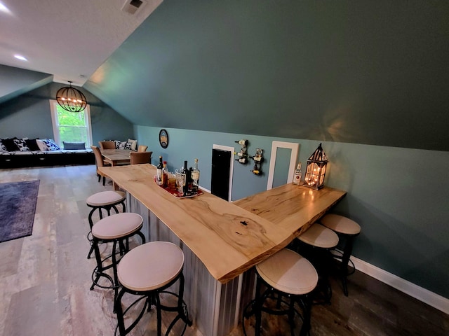 bar featuring hardwood / wood-style floors and lofted ceiling