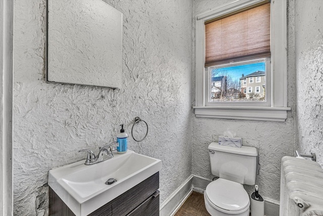 bathroom featuring vanity, radiator, and toilet