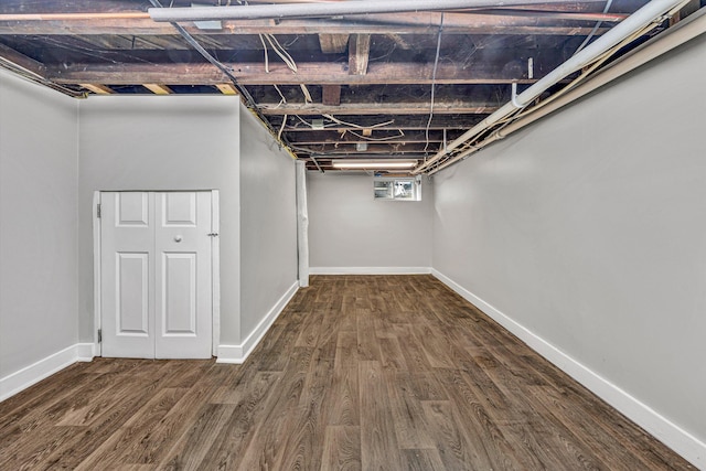 basement with dark hardwood / wood-style floors