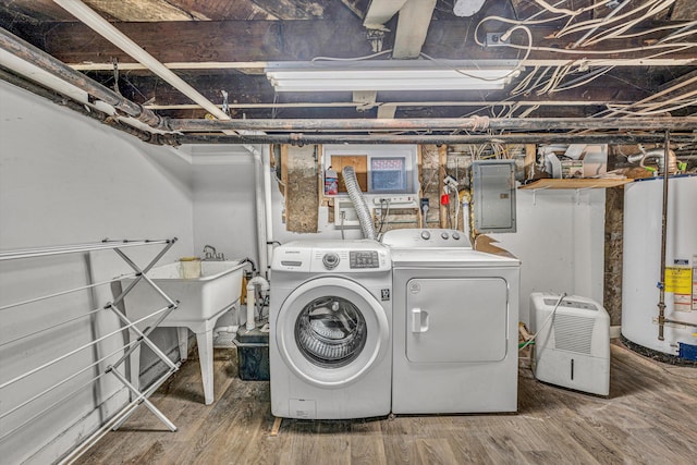 clothes washing area with hardwood / wood-style floors, gas water heater, electric panel, and washing machine and clothes dryer