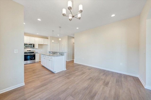 kitchen featuring appliances with stainless steel finishes, a kitchen island, light hardwood / wood-style floors, white cabinetry, and hanging light fixtures