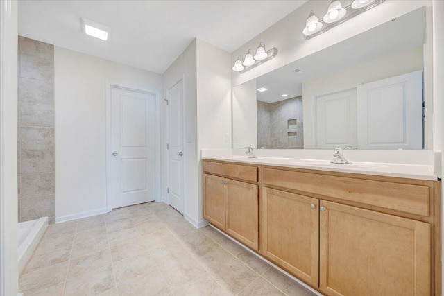 bathroom featuring tile patterned floors, vanity, and a tile shower