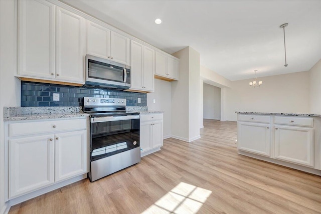 kitchen featuring white cabinets, pendant lighting, appliances with stainless steel finishes, and tasteful backsplash