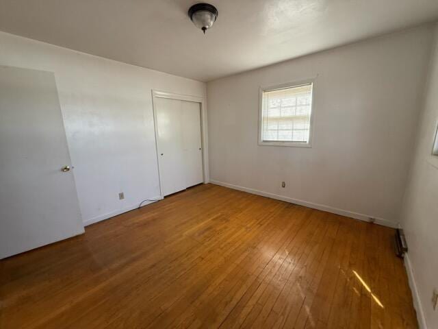 unfurnished bedroom with hardwood / wood-style flooring and a closet