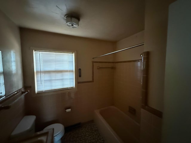 bathroom with tile walls and toilet