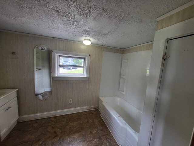 bathroom with vanity, a textured ceiling, and wood walls