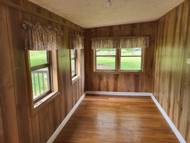 unfurnished room featuring hardwood / wood-style flooring and wood walls