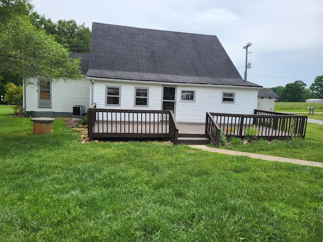 rear view of house featuring a lawn, central AC unit, and a deck