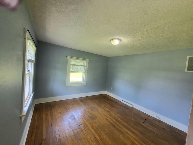 unfurnished room featuring dark wood-type flooring and a textured ceiling