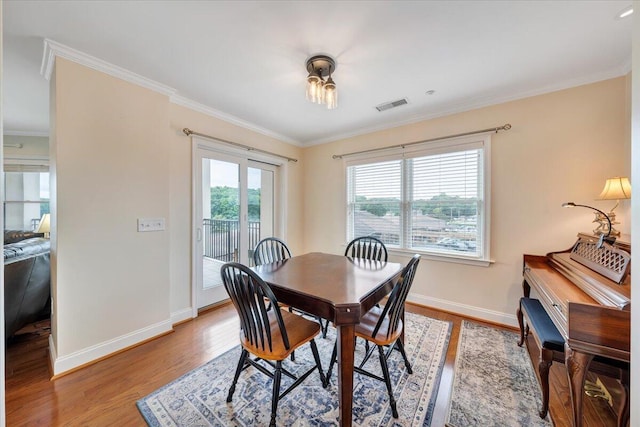 dining space with ornamental molding and hardwood / wood-style flooring