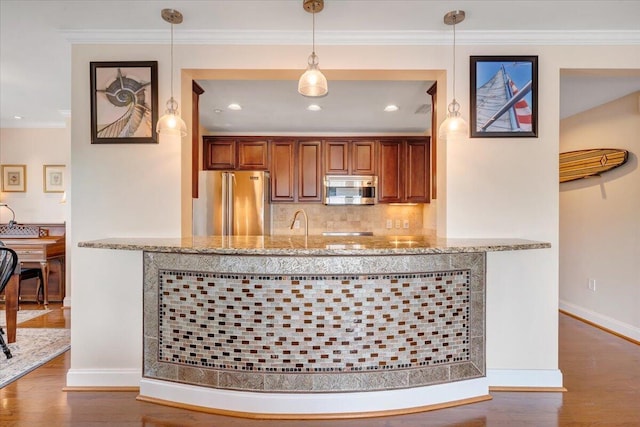 kitchen with light stone counters, hanging light fixtures, stainless steel appliances, tasteful backsplash, and wood-type flooring