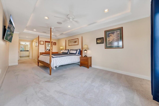 bedroom with light carpet, ceiling fan, and a tray ceiling