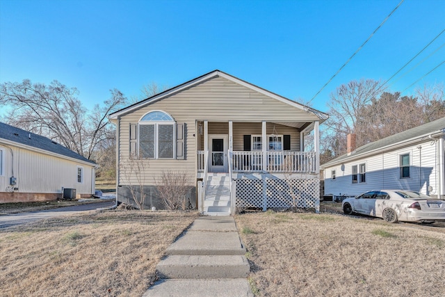 bungalow-style house featuring a front yard, covered porch, and central AC