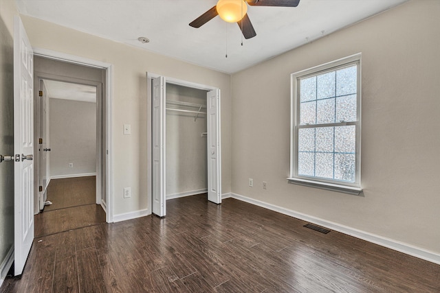 unfurnished bedroom featuring ceiling fan and dark hardwood / wood-style flooring