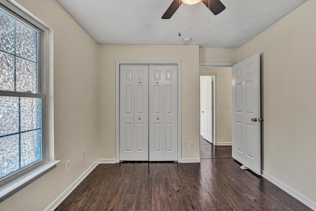 unfurnished bedroom with ceiling fan, a closet, and dark hardwood / wood-style floors