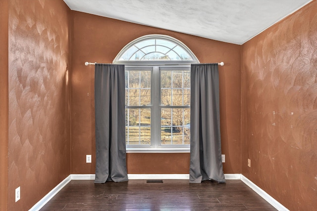 spare room with a wealth of natural light and hardwood / wood-style flooring