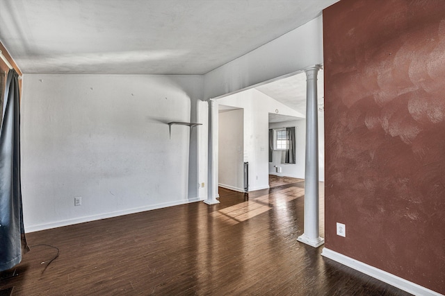 empty room featuring lofted ceiling and dark wood-type flooring