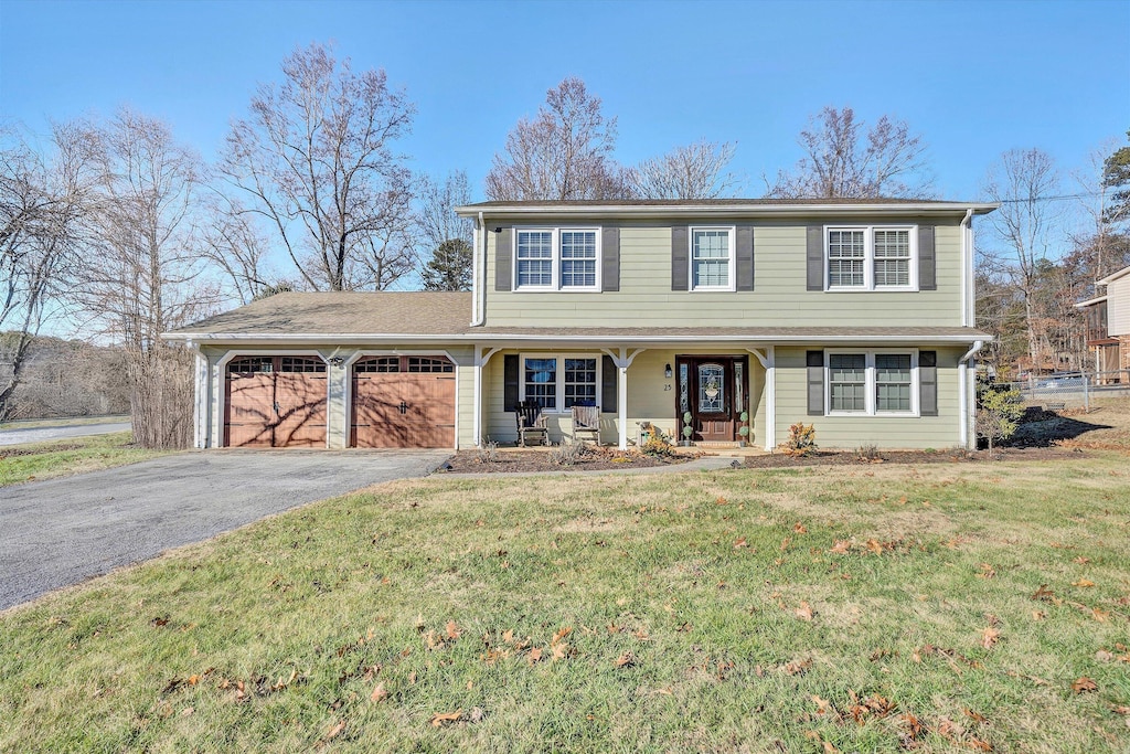 view of front of home with covered porch, a garage, and a front lawn