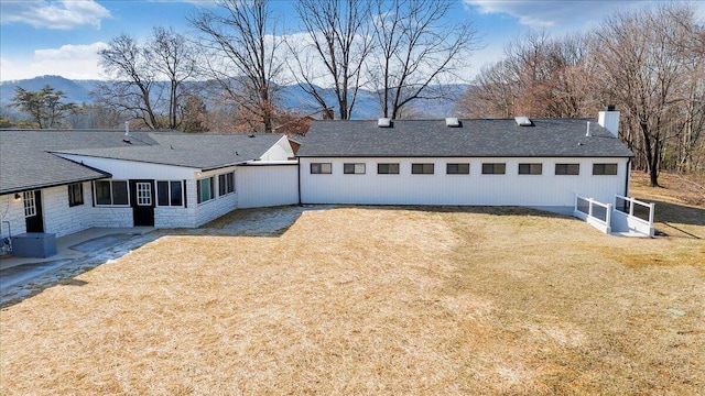 view of front of home featuring a mountain view and a front lawn