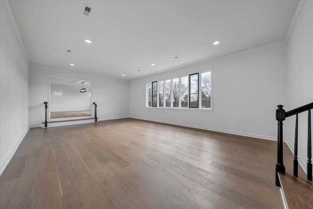 unfurnished living room featuring crown molding and wood-type flooring