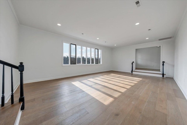 spare room featuring crown molding and light hardwood / wood-style flooring