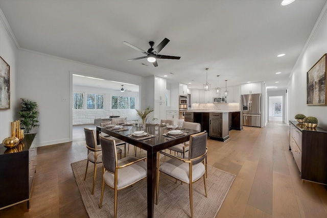 dining room with crown molding, ceiling fan, and light hardwood / wood-style floors