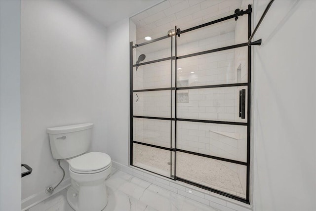 bathroom with a tile shower and toilet