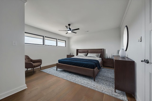 bedroom with crown molding, hardwood / wood-style flooring, and ceiling fan