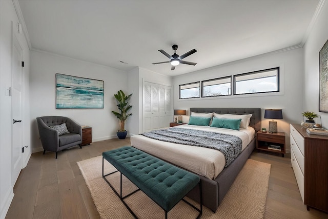 bedroom with ceiling fan, a closet, ornamental molding, and light hardwood / wood-style flooring