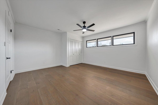 unfurnished bedroom featuring crown molding, ceiling fan, hardwood / wood-style floors, and a closet