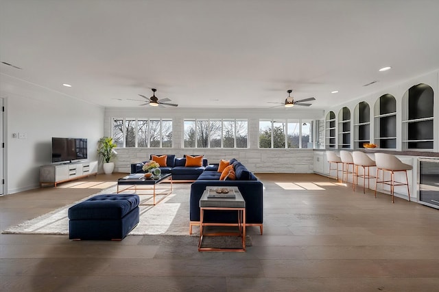 living room with crown molding, hardwood / wood-style floors, and ceiling fan