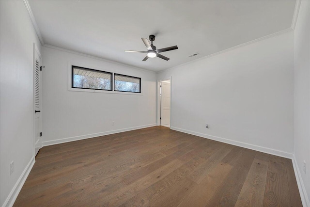 empty room featuring dark wood-type flooring, ceiling fan, and crown molding