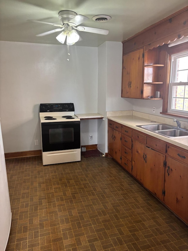 kitchen featuring visible vents, baseboards, light countertops, electric stove, and a sink