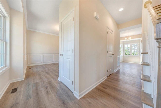 hallway with a chandelier and light hardwood / wood-style flooring