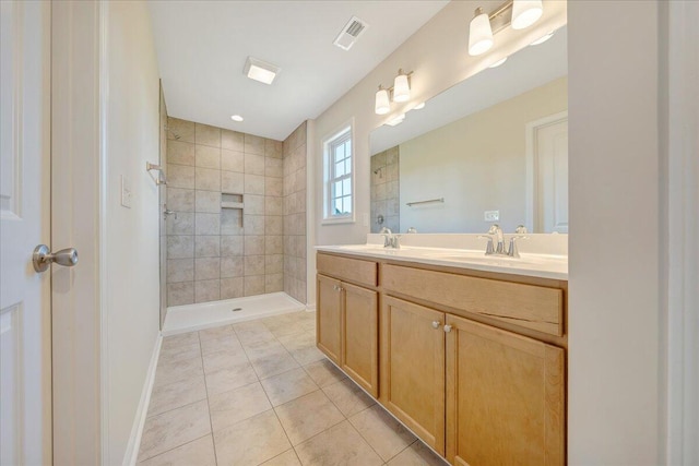 bathroom with tiled shower, vanity, and tile patterned floors