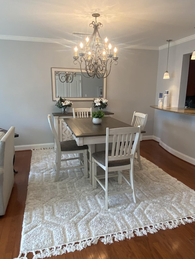 dining area featuring a chandelier, hardwood / wood-style floors, and ornamental molding