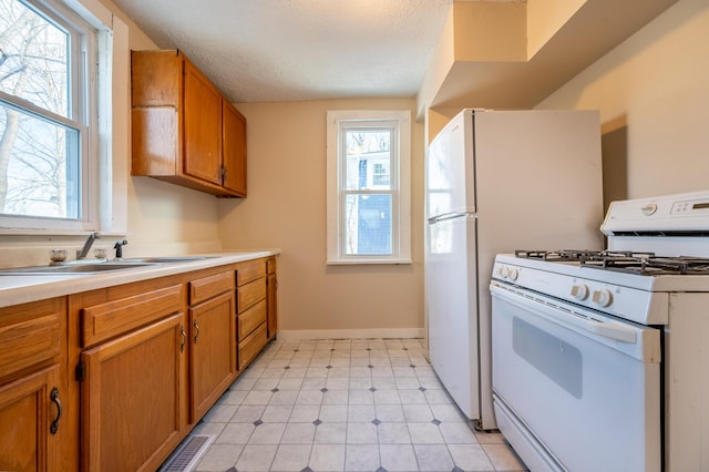 kitchen featuring sink, gas range gas stove, and a healthy amount of sunlight